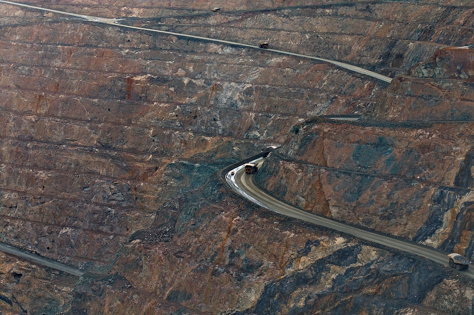 Aerial view of an open-pit iron ore mine with haul trucks